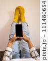 Feet up and using phone at home, relaxing moment. 111480654