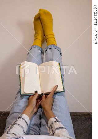 Woman reading a book with feet up and in a cozy mood 111480657