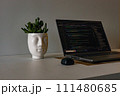 High quality image of a laptop sitting on table. Work from home setup with flower and headphones.  111480685