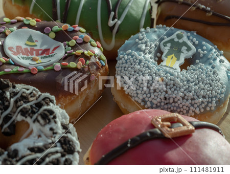 Many Glazed Doughnuts placed on wooden cutting board. 111481911