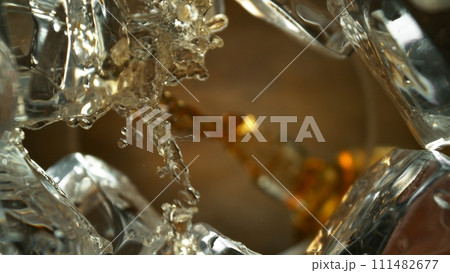 Pouring Whiskey into Glass, Macro Shot. Pouring Whiskey into Glass, Macro Shot. 111482677