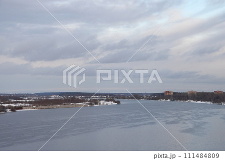 river on a sunny evening. Trees and shrubs. Landscape of winter nature, river banks overgrown with bushes. 111484809