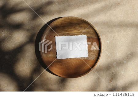 Boho wedding invitation. Blank greeting, business card mockup on wooden tray in sunlight. Harsh tree branches shadows. Beige marble stone texture, background. Summer stationery template. Flat lay, top Boho wedding invitation. Blank greeting, business card mockup on wooden tray in sunlight. Harsh tree branches shadows. Beige marble stone texture, background. Summer stationery template. Flat lay, top 111486118