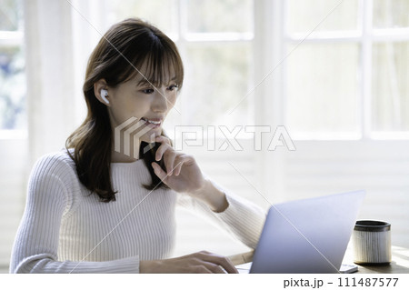 明るいリビングでオンライン会議をする女性 明るいリビングでオンライン会議をする女性 111487577
