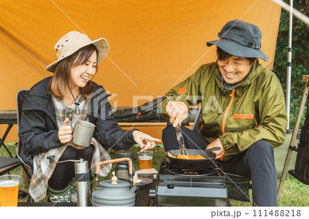 秋冬のキャンプ場でキャンプ飯を作る男女のキャンパー 秋冬のキャンプ場でキャンプ飯を作る男女のキャンパー 111488218