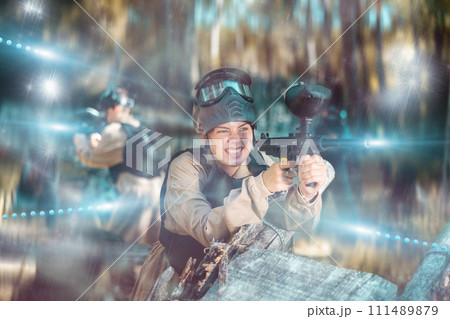 Woman fires a gun with passion while playing paintball 111489879