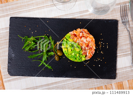 Raw salmon tartare with avocado and onion 111489913