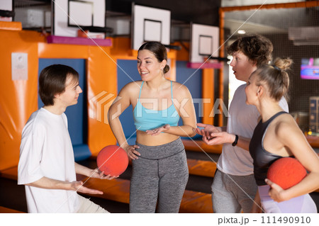 Young people in sport clothes talking merrily in trampoline arena 111490910