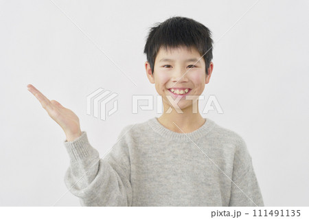 手のひらで左側を指す男の子　白背景 111491135