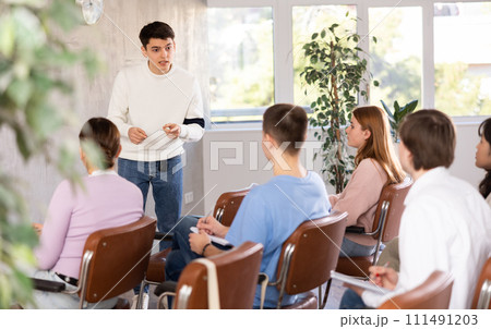 Teenagers boys an girls listen to an interesting story of an classmate in school 111491203