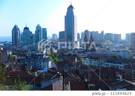 高台から眺めた中国の青島、黄砂に霞む高層ビル街と、ドイツ租借地時代の赤瓦屋根の建築群 高台から眺めた中国の青島、黄砂に霞む高層ビル街と、ドイツ租借地時代の赤瓦屋根の建築群 111493625