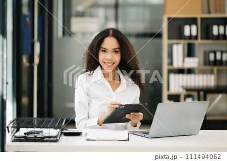 Confident business expert attractive smiling young woman holding digital tablet  . 111494062