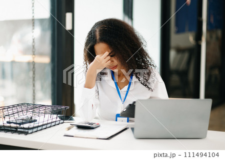 business woman is stressed, bored, and overthinking from working on a tablet. business woman is stressed, bored, and overthinking from working on a tablet. 111494104