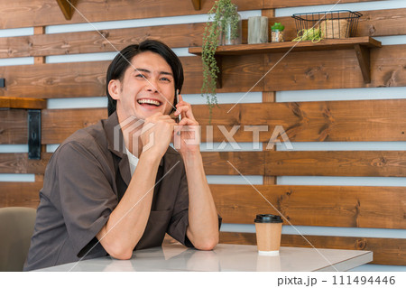 カフェでスマホで通話するアジア人男性（マナー・マナー違反・迷惑） 111494446