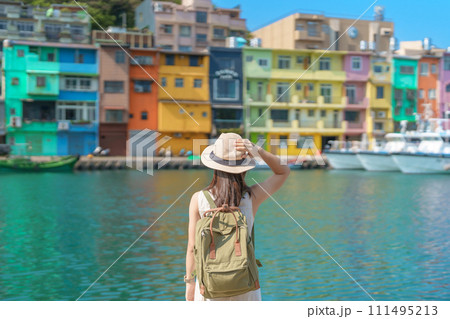 woman traveler visiting in Taiwan, Tourist with backpack and hat sightseeing in Keelung, Colorful Zhengbin Fishing Port, landmark and popular attractions near Taipei city . Asia Travel concept 111495213