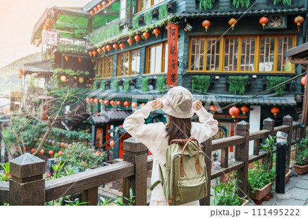 woman traveler visiting in Taiwan, Tourist with hat and backpack sightseeing in Jiufen Old Street village with Tea House background. landmark and popular attractions near Taipei city. Travel concept 111495222
