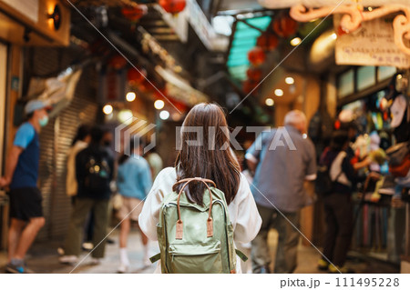 woman traveler visiting in Taiwan, Tourist with hat and backpack sightseeing and shopping in Jiufen Old Street market. landmark and popular attractions near Taipei city. Travel and Vacation concept 111495228