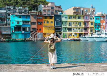 woman traveler visiting in Taiwan, Tourist with backpack and hat sightseeing in Keelung, Colorful Zhengbin Fishing Port, landmark and popular attractions near Taipei city . Asia Travel concept 111495622