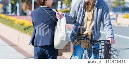 自転車に乗って鞄をひったくりする男性 111496421