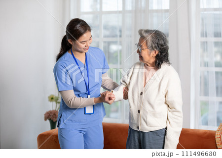 Happy asian female doctor helping elderly patient walking with cane or walking stick at home.Nures or caregiver assistance and support senior patient trying to walk with safety cheerful and encouraged Happy asian female doctor helping elderly patient walking with cane or walking stick at home.Nures or caregiver assistance and support senior patient trying to walk with safety cheerful and encouraged 111496680