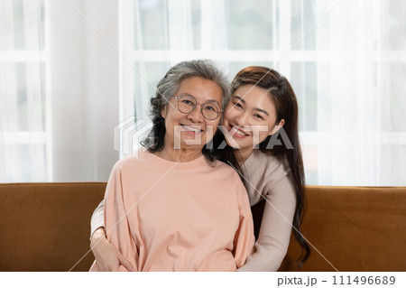 Heartfelt moment as a mid-age woman embraces her elderly mother with a warm and loving hug, celebrating the enduring bond between generations. Family Love Concept Heartfelt moment as a mid-age woman embraces her elderly mother with a warm and loving hug, celebrating the enduring bond between generations. Family Love Concept 111496689