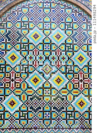 Detail of traditional persian mosaic wall with ornament of blue, dark blue and yellow color, Iran. Colorful geometric mosaic in arch, Tehran 111498294