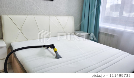 The concept of cleaning and housekeeping. Dry cleaning of the mattress by a professional method. 111499733