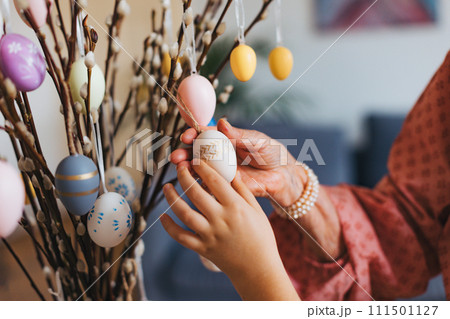 Close up of decorating pussy willows branches, putting easter eggs on them. Close up of decorating pussy willows branches, putting easter eggs on them. 111501127