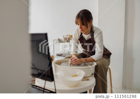 Professional female artisan shaping clay bowl in pottery studio. Ceramics art concept 111501298