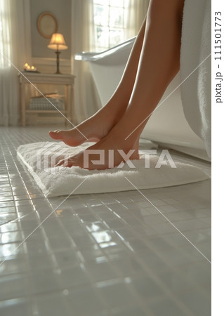 Womans feet with perfect pedicure on a white fluffy carpet in a beautiful white bathroom 111501773