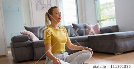 Woman exercising at home, stretching her body. Solo home workout and meditation, morning or evening workout routine. Banner with copy space. Woman exercising at home, stretching her body. Solo home workout and meditation, morning or evening workout routine. Banner with copy space. 111501859