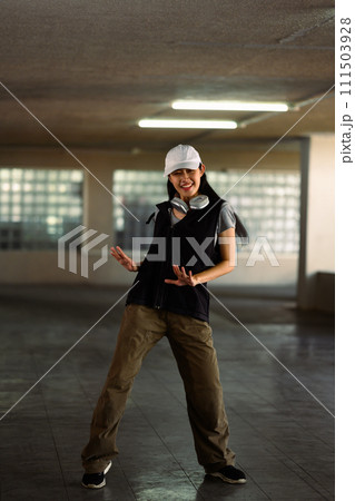 Full length of young woman practicing vigorous hip hop movements in parking garage 111503928