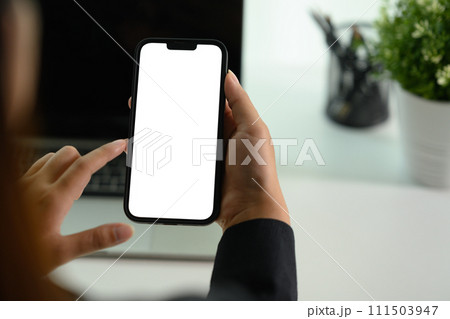 Female worker using mobile phone at her office desk. Closeup, blank screen for your advertising text. 111503947