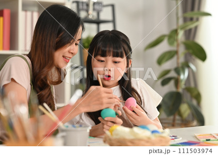 Little girl child girl and her mother painting Easter egg with colorful paints at home Little girl child girl and her mother painting Easter egg with colorful paints at home 111503974