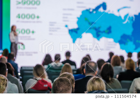 Professional speaker presenting at business conference, audience engagement 111504574
