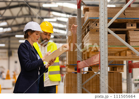 Female manager talking with foreman. Warehouse, production worker preparing products for shipment. Woman quality controller checking quality of products, talking with technician. Female manager talking with foreman. Warehouse, production worker preparing products for shipment. Woman quality controller checking quality of products, talking with technician. 111505664