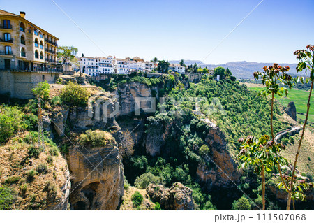 Ronda town and valley, Andalusia, Spain. Popular landmark. Tourist attraction at sunset light, place to visit. View from the city on valley 111507068