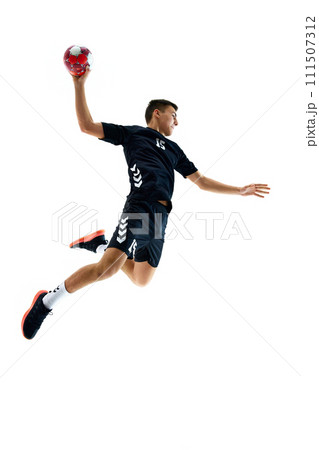 Full-length image of young handball athlete in motion during game, throwing ball against white studio background. Motivation to win Full-length image of young handball athlete in motion during game, throwing ball against white studio background. Motivation to win 111507312