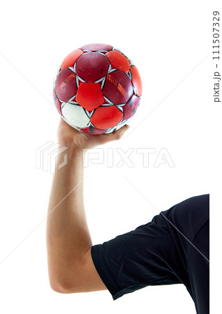 Male hand holding handball ball against white studio background. Attributes of game 111507329