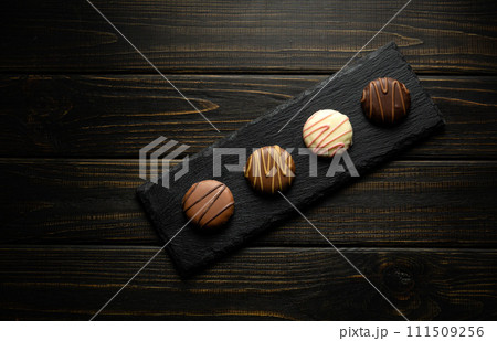 Round chocolate brownie on a black serving board. Delicious dessert concept on vintage dark kitchen table 111509256