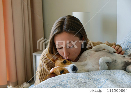 Woman with her jack russell pup at home. 111509864