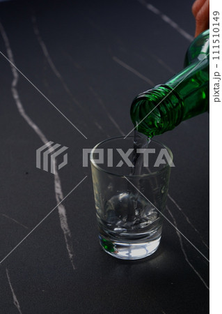 韓国の焼酎（ソジュ）をグラスに注ぐ 111510149