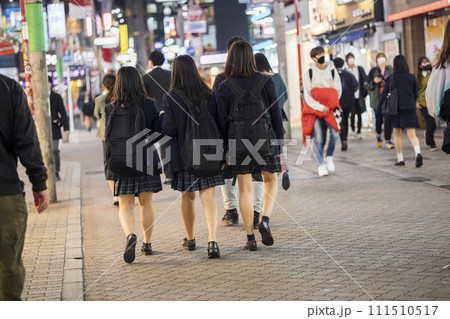 夜の渋谷センター街を歩く制服の女子高生の後ろ姿 111510517