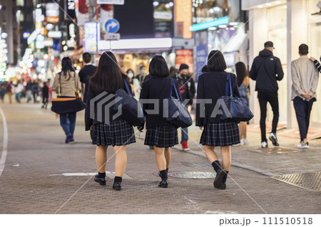夜の渋谷センター街を歩く制服の女子高生の後ろ姿 111510518