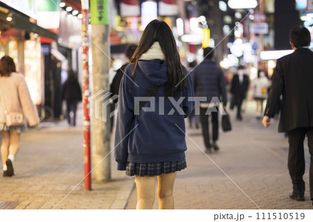 夜の渋谷センター街を歩く制服の女子高生の後ろ姿 111510519