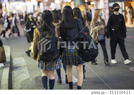 夜の渋谷センター街を歩く制服の女子高生の後ろ姿 111510521