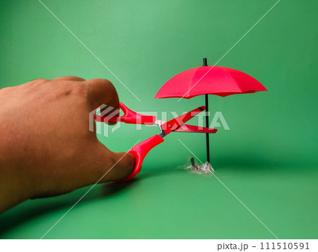 Someone wants to cut a red umbrella using red scissors Someone wants to cut a red umbrella using red scissors 111510591