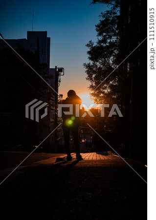 夕日をのぞむ女性のシルエット 111510915