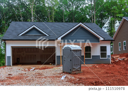 Portable temporary toilet is located on construction site during build home Portable temporary toilet is located on construction site during build home 111510978