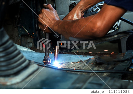 Close up of welding auto body with gas torch at auto repair shop Close up of welding auto body with gas torch at auto repair shop 111511088